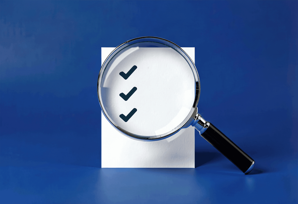 Magnifying glass examining a checklist card representing transparent website package contents