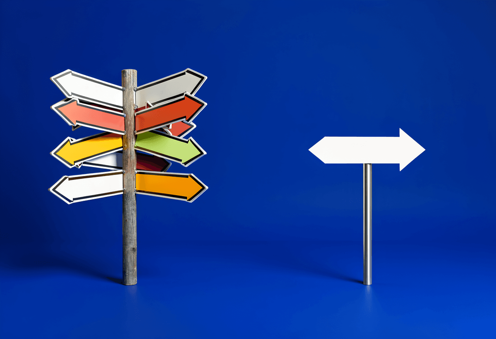 Confusing cluttered multi-arrow signpost versus clean simple directional arrow on royal-blue background